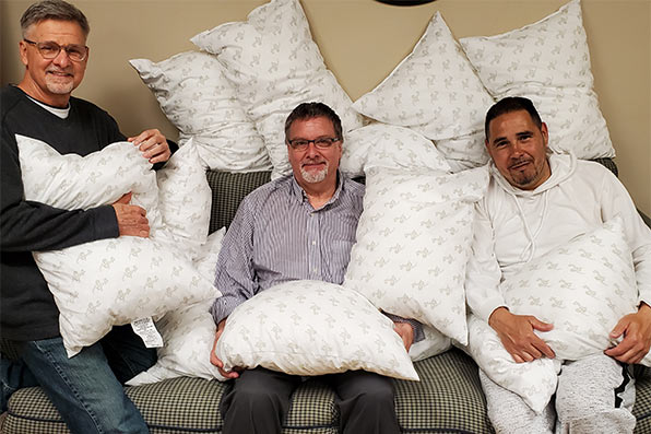 Men pose with pillows
